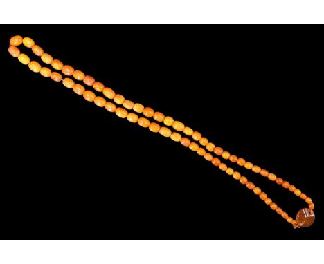 A vintage butterscotch amber and jade necklace, comprising a string of subtly graduated hand-cut beads connecting at a 22 mm 