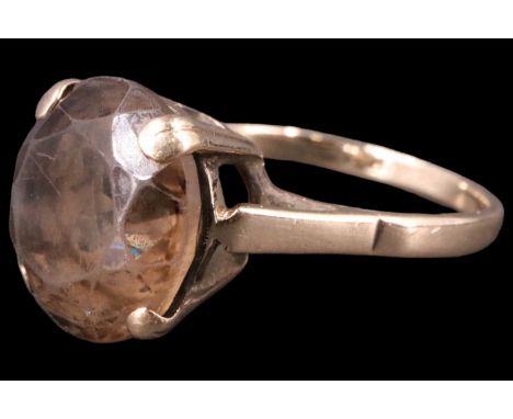 A late 20th Century smoky quartz finger ring, comprising a smoky quartz brilliant of approximately 5 carats set between open 