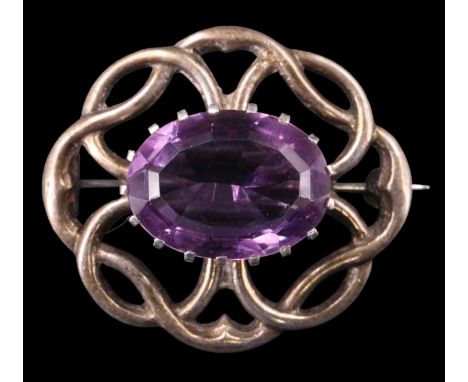 A vintage Scottish amethyst brooch, having an oval of approximately 18 carats (18 x 13 mm) in a crown setting and surrounded 