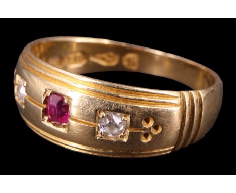 A Victorian diamond and ruby finger ring, having a 2.5 mm ruby between two 2 mm diamond brilliants, gypsy-set on a tapering b