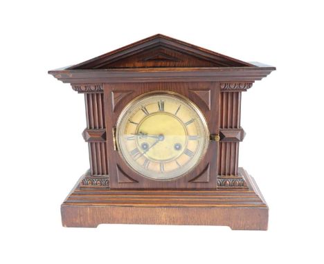 An early 20th Century German oak mantle clock by Junghans, striking on a gong in an architectural case with a pediment, 36 x 