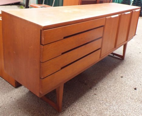 A vintage retro mid 20th Century Danish teak wood sideboard by Beautility with three cupboards and four drawers