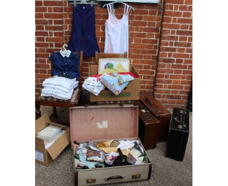 A large assortment of vintage items including as new boiler suits, suitcases, underwear, children's clothes, scarves, table c