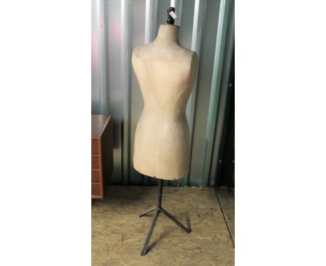A vintage mannequin or tailor's dummy on black metal tripod base