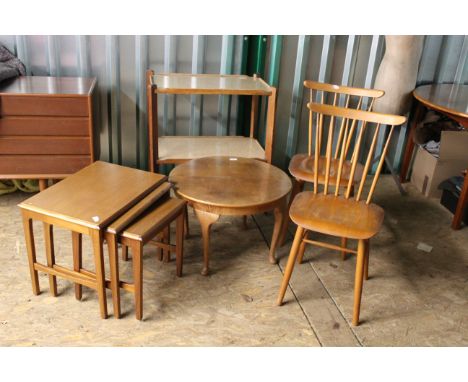 A collection of vintage wooden furniture including a nest of tables, two kitchen chairs, occasional table and a tea trolley