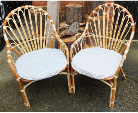 A pair of vintage bamboo conservatory armchairs and matching circular table