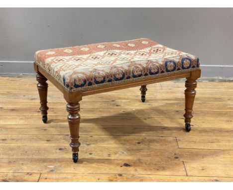 A Victorian walnut duet stool, the seat upholstered in period embroidered fabric worked in a geometric and floral design, rai