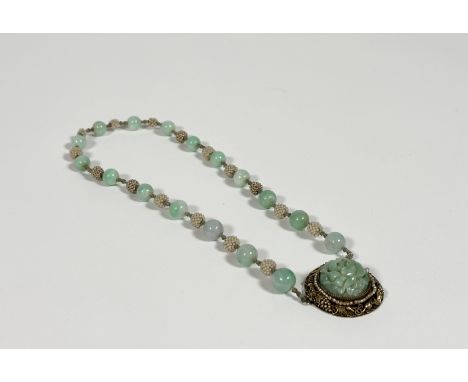 A Chinese jadeite single strand bead necklace, the uniform spherical celadon beads spaced by small glass or paste pearl clust