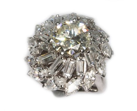 A diamond cluster ring in the manner of Boucheron, circa 1960s, the principal round brilliant cut diamond weighing approx. 2.