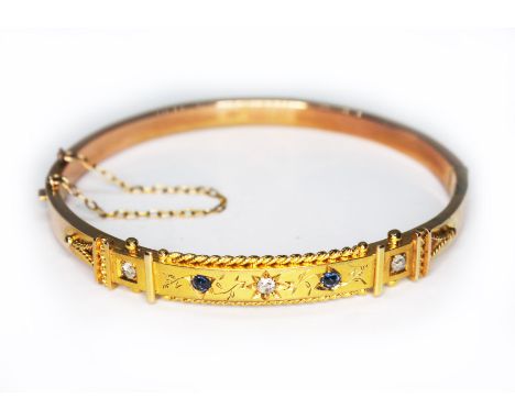 A late Victorian diamond and sapphire bangle, Etruscan style with rope twist and bead details, marked '9ct', oval shape, 6cm 