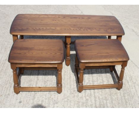 An Ercol 17th Century style nest of three elm coffee tables
