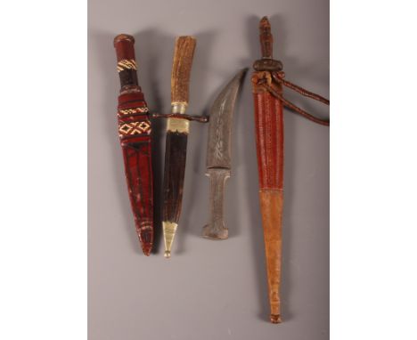 A staghorn handled dagger and scabbard, three Middle Eastern daggers, various, and a Middle Eastern brass powderhorn