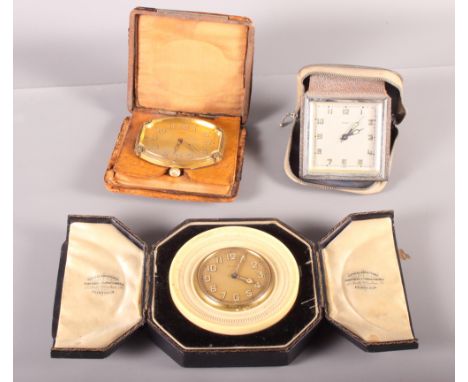 Three cased travelling clocks with eight-day movements, one in carved circular ivory frame