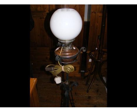 An antique wrought iron standard lamp