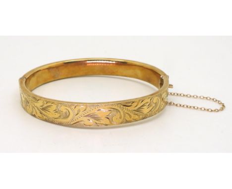 A 9ct gold engraved hollow bangle, inner dimensions 6.1cm x 5.4cm, weight 12.8gms Condition Report:Available upon request