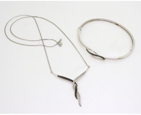 A 9ct white gold black and white diamond bangle and necklace set, weight together 9.3gms Condition Report:Available upon requ
