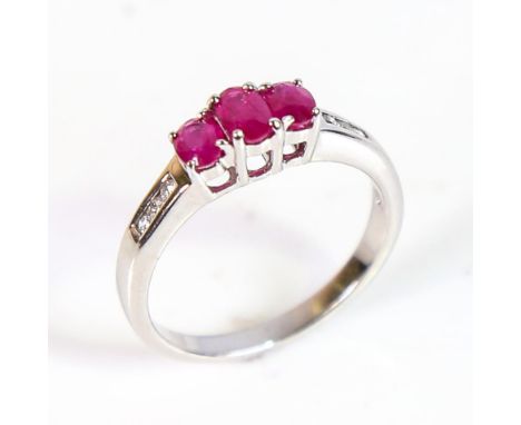 A modern 9ct white gold ruby and diamond dress ring, set with oval mixed-cut rubies and round brilliant-cut diamonds, setting