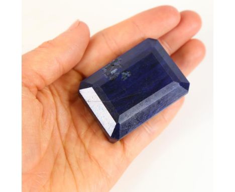 599.00ct unmounted rectangular step-cut sapphire, 48.00mm x 35.00mm x 25.00mm, evidence of colour enhancement, 120.07g, with 