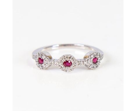 A modern 18ct white gold ruby and diamond triple cluster dress ring, set with round-cut rubies and modern round brilliant-cut