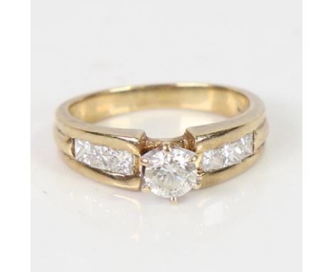 A modern 9ct gold solitaire diamond ring, round brilliant-cut diamond with Princess-cut diamond shoulders, total diamond cont