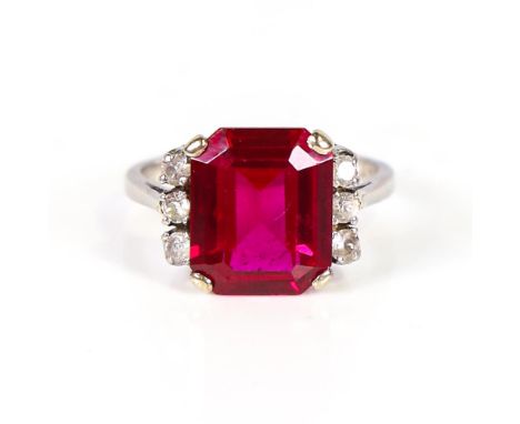 An Art Deco platinum synthetic ruby and cubic zirconia dress ring, set with large emerald-cut synthetic ruby and round-cut di