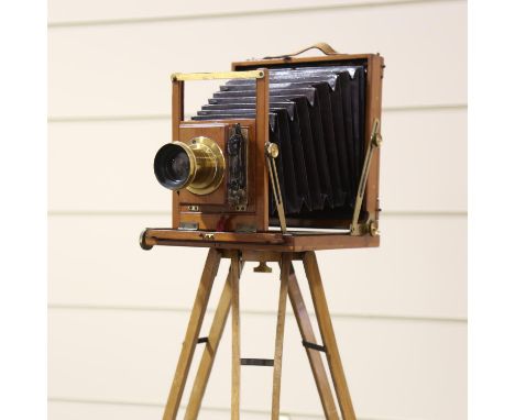 A mahogany and brass plate camera, circa 1900, the brass lens inscribed Dollond London Rapid Rectilinear 6 1/2 x 4 3/4, Secon