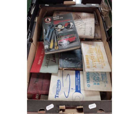 A box of motorcycle and car manuals including Triumph, BSA, Yamaha, Mini, Ariel, Lambretta, etc.