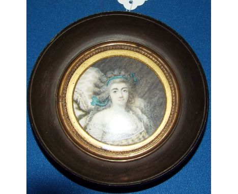 A bust portrait miniature, of a lady with a blue ribbon in her hair, watercolour, dated 1789, 6 cm diameter