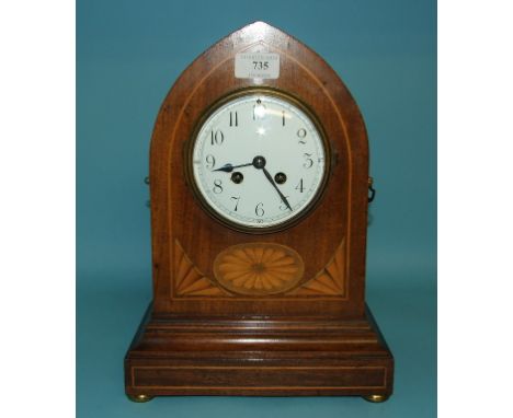 An Edwardian mantel clock, the 11 cm diameter enamel dial with Arabic numerals, in an inlaid mahogany lancet case, 34 cm high