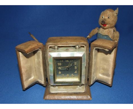 A miniature travelling clock, in a mother of pearl case, cased, a Schuco style clockwork bear playing a drum, and another sim