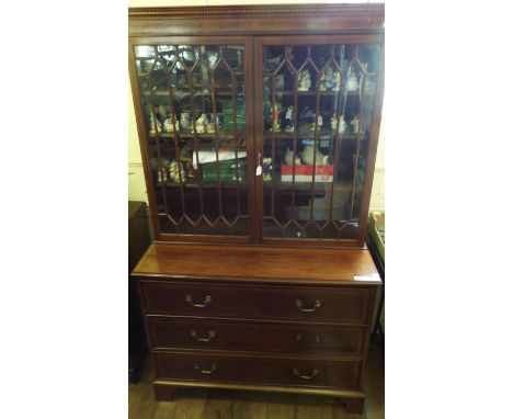 A George III style inlaid mahogany secretaire bookcase, having a pair of bar glazed doors above a secretaire drawer with two 