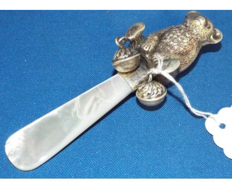 A silver and mother of pearl rattle, in the form of a teddy bear