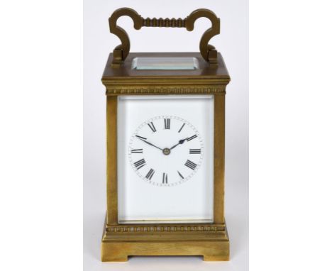 A carriage clock, the 7 cm wide enamel dial with Roman numerals, fitted a movement striking on a gong, in a four pillar brass
