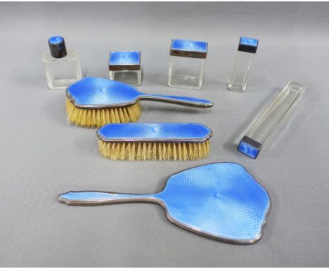 George VI blue leather vanity case containing an eight piece silver and blue guilloche enamel set of brushes, bottles and jar