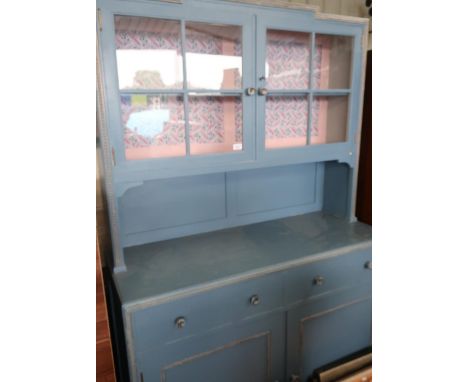 Vintage kitchen dresser with two glazed door above two drawers and two panelled doors on square supports, vintage blue painte