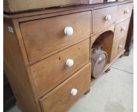 Early C20th waxed pine dog kennel type dresser, with seven drawers with ceramic handles around an aperture W167cm D23cm H91cm