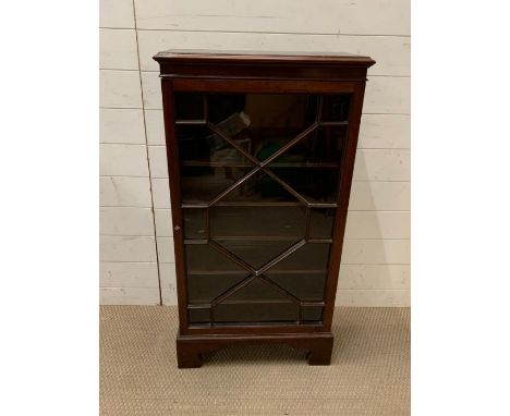 A glazed bookcase/side cabinet on bracket feet (H106cm W56cm D24cm)