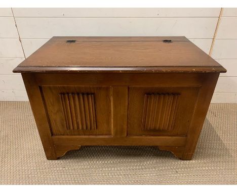 A wooden chest on bracket feet and linen fold panels to front (50 cm x 47 cm x 80cm)