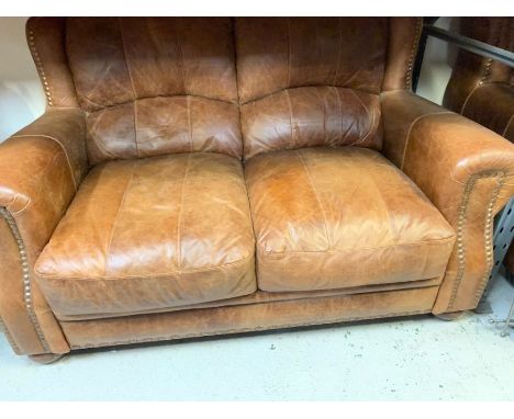 A brown leather two seater sofa