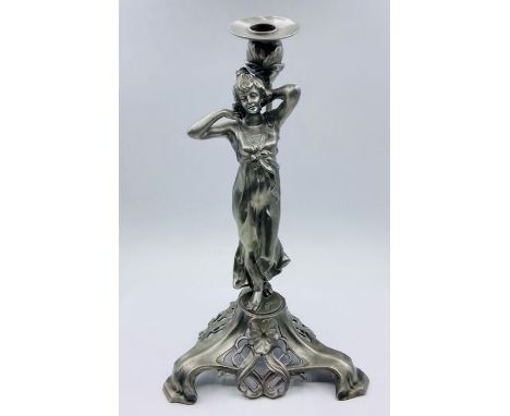 An Art Nouveau style candlestick of a lady signed to base.