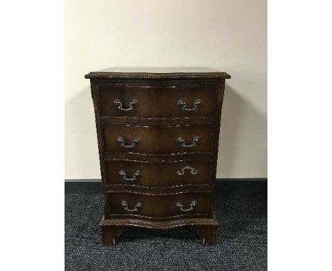 A mahogany serpentine fronted four drawer chest on bracket feet 