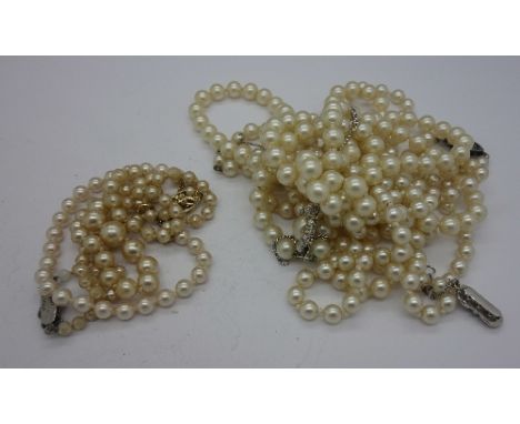 Four faux pearl necklaces and a bracelet with silver clasps