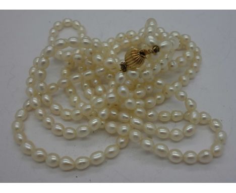 A three row pearl necklace with 14ct gold fastener