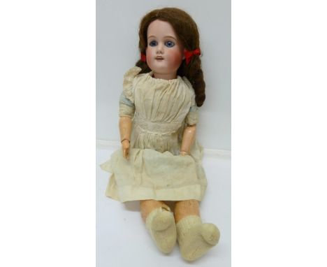 A jointed bisque-head doll with fixed blue eyes, head marked Fabrication Francaise, AL & Co., Limoges, height 49cm, both hand