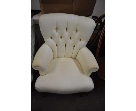A cream button backed tub chair