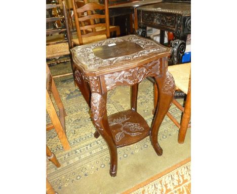 A dark Mahogany/Ebonised finish occasional table having carved Chrysanthemum detail to the top, floral carved knees to the ca