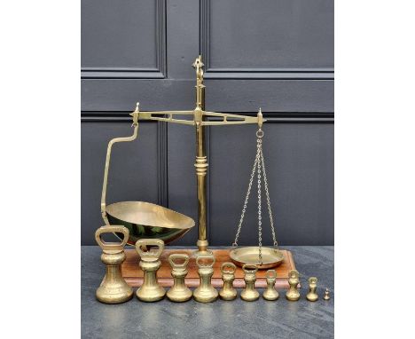 A set of brass and mahogany balance scales,&nbsp;by Banfield, Brighton, 56cm high; together with ten bell weights.