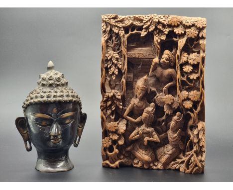 A Sino-Tibetan bronze Buddha's head, 21.5cm high; together with a Thai carved wood panel, 30 x 21cm. (2)