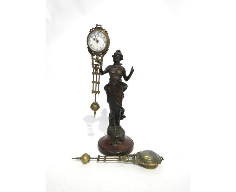 A Junghans figural form spelter mystery clock, with spare clock case, on wooden plinth, figure is 29cm tall
