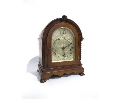 An English oak cased bracket clock, with ornately engraved silvered dial having Roman numeral chapter ring and a Chime/Silent